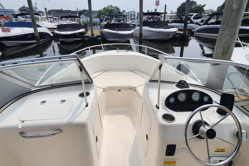 Slide: The Image of 2001 Sea Hunt 19 Dual Console boat interior at marina, featuring steering wheel and dashboard. - 4