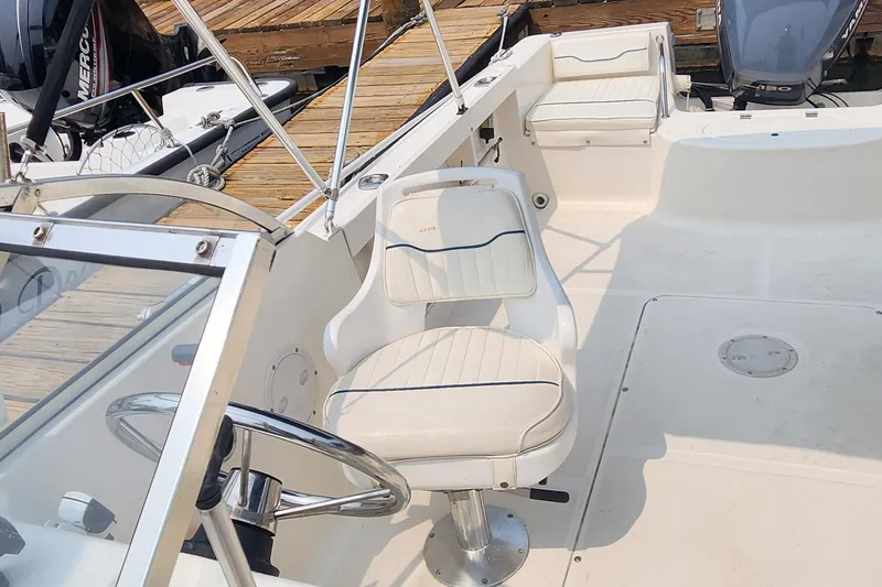 Slide: The Image of 2001 Sea Hunt 19 Dual Console boat interior with white seating and steering wheel. - 6