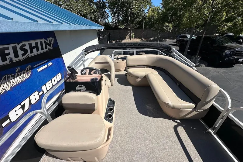 Slide: The Image of 2019 Sun Tracker Bass Buggy 18 DLX pontoon boat with beige seating and outdoor setting. - 12