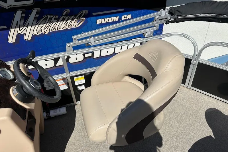Slide: The Image of 2019 Sun Tracker Bass Buggy 18 DLX boat interior with steering wheel and beige captain's chair. - 19