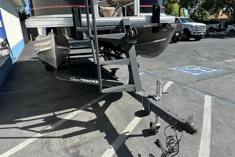Slide: The Image of 2019 Sun Tracker Bass Buggy 18 DLX pontoon boat on trailer in parking lot. - 4