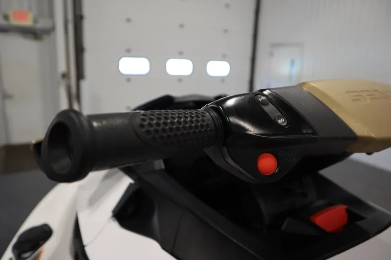 Slide: The Image of Close-up of 2013 Sea-Doo GTX 215 handlebar with control buttons in a garage setting. - 15