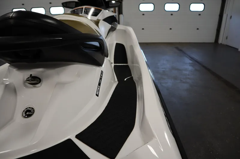 Slide: The Image of 2013 Sea-Doo GTX 215 jet ski in a garage, showcasing sleek design and seating. - 21