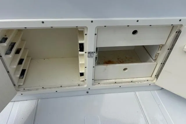Slide: The Image of Storage compartments on a 2004 Jupiter 31 Center Console boat, featuring open shelves and drawers. - 17