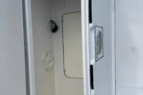 Slide: The Image of 2004 Jupiter 31 Center Console storage compartment, open hatch, white interior. - 23