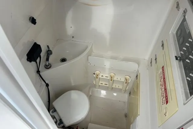 Slide: The Image of 2004 Jupiter 31 Center Console boat interior with sink and toilet. - 26