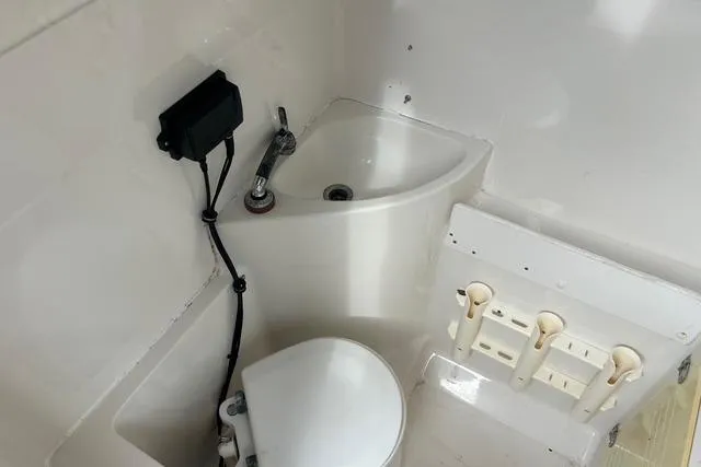 Slide: The Image of 2004 Jupiter 31 Center Console boat bathroom with sink and toilet. - 27