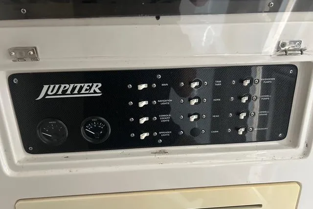 Slide: The Image of Control panel of a 2004 Jupiter 31 Center Console boat with switches and gauges. - 28
