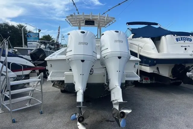 Slide: The Image of 2004 Jupiter 31 Center Console boat with twin outboard engines, docked beside other vessels. - 3