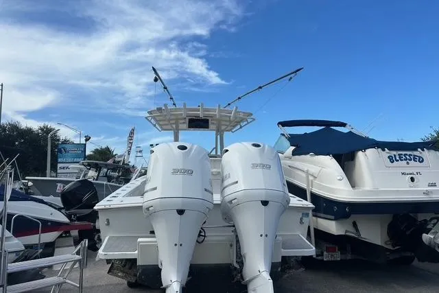 Slide: The Image of 2004 Jupiter 31 Center Console boat with dual engines, docked alongside other vessels. - 4