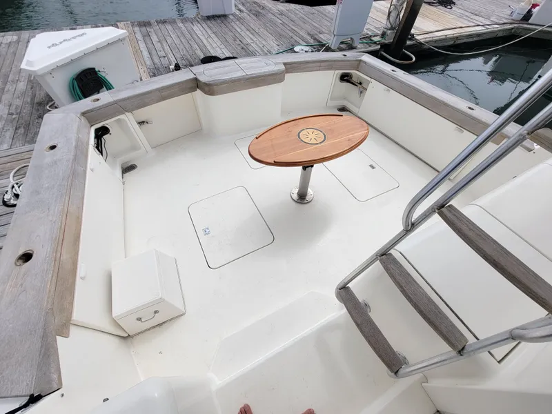 Slide: The Image of Cockpit of 2001 Ocean Yachts 56 Super Sport with wooden table and docked at marina. - 45