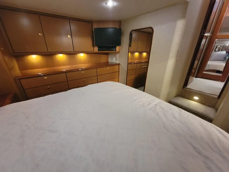 Slide: The Image of Luxurious bedroom interior of 2001 Ocean Yachts 56 Super Sport with ample storage and TV. - 26
