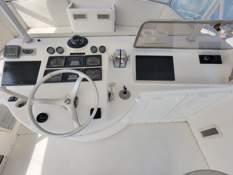 Slide: The Image of 2001 Ocean Yachts 56 Super Sport helm station with steering wheel and navigation instruments. - 6