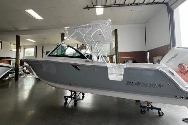 The Image of 2026 Blackfin 252 DC boat in showroom, side view, gray and white design. - 0