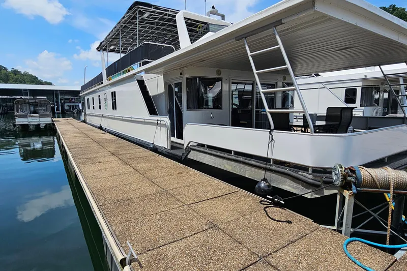The Image of Houseboat docked at marina, Fantasy 18x80 model, 2001, under clear blue sky. - 0