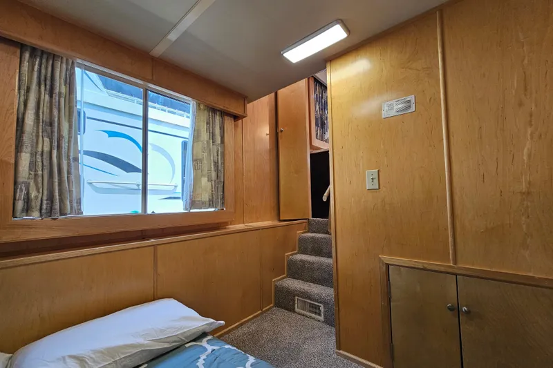 Slide: The Image of Interior of a 2001 Fantasy 18x80 houseboat with wooden walls and carpeted stairs. - 12