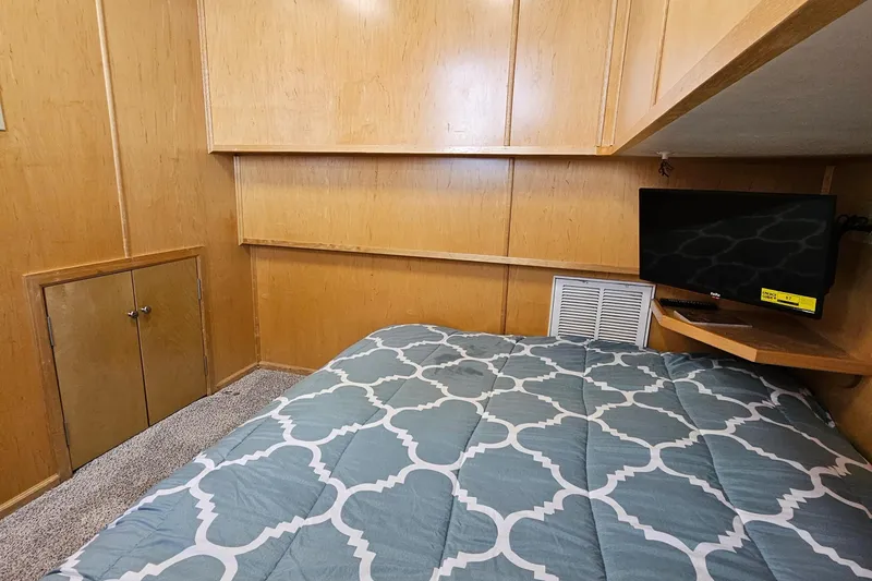 Slide: The Image of Cozy bedroom with wood paneling, patterned bedding, and a small wall-mounted TV. - 15