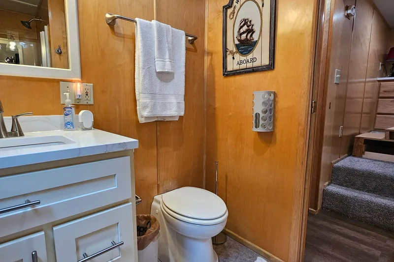 Slide: The Image of Small bathroom with wooden walls, white vanity, and nautical decor in a 2001 Fantasy model. - 17