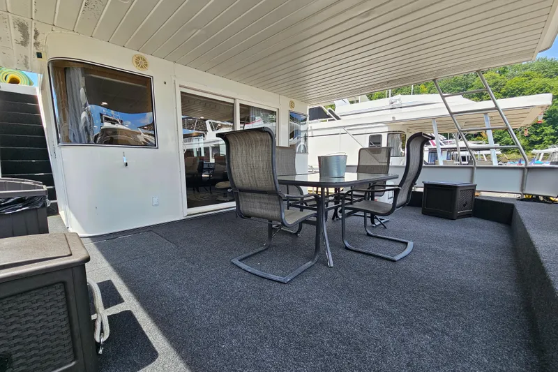 Slide: The Image of Outdoor deck of a 2001 Fantasy 18x80 houseboat with seating and table. - 2