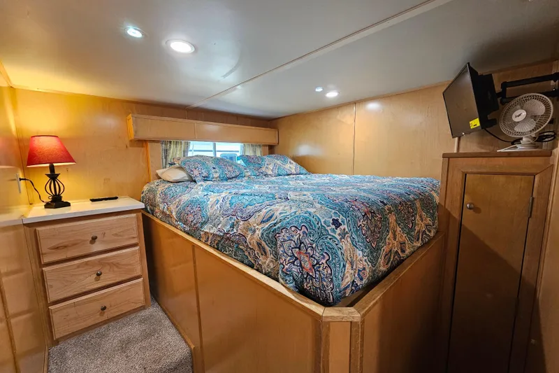 Slide: The Image of Cozy bedroom in a 2001 Fantasy 18x80 houseboat with vibrant bedding and warm lighting. - 20