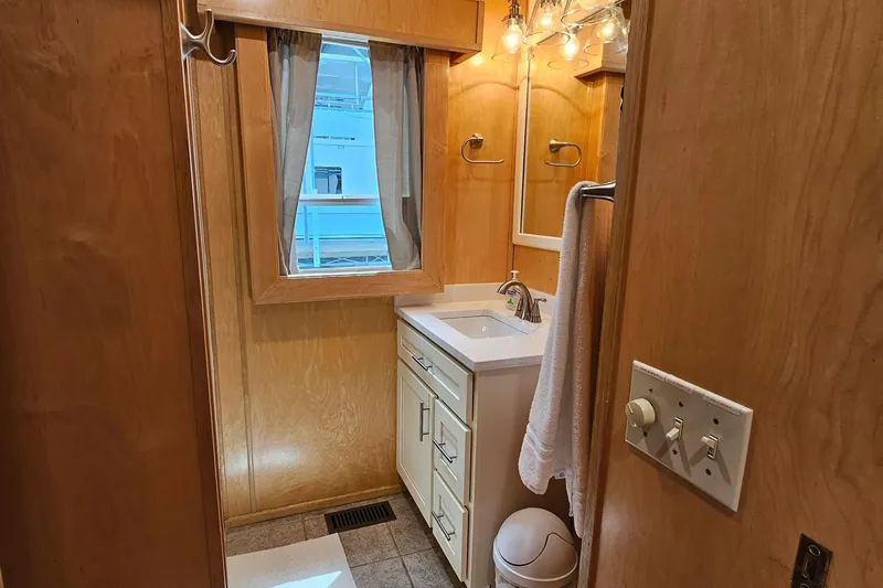 Slide: The Image of Compact bathroom with wooden walls, white sink, mirror, and window in a 2001 Fantasy model. - 22