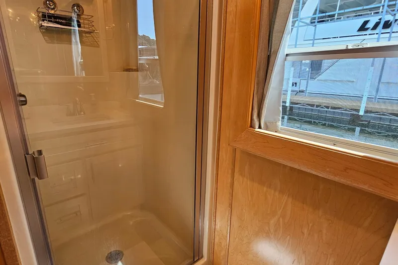 Slide: The Image of Shower area in a 2001 Fantasy 18x80 houseboat with wooden interior and window view. - 28