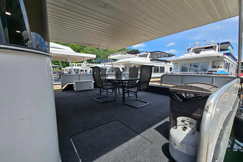 Slide: The Image of Outdoor deck of 2001 Fantasy 18x80 houseboat with chairs and table, docked at marina. - 3