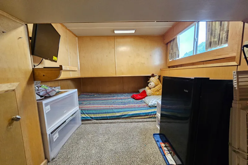 Slide: The Image of Cozy bedroom with striped bedding, TV, storage drawers, and mini fridge in a Fantasy 18x80 model. - 37