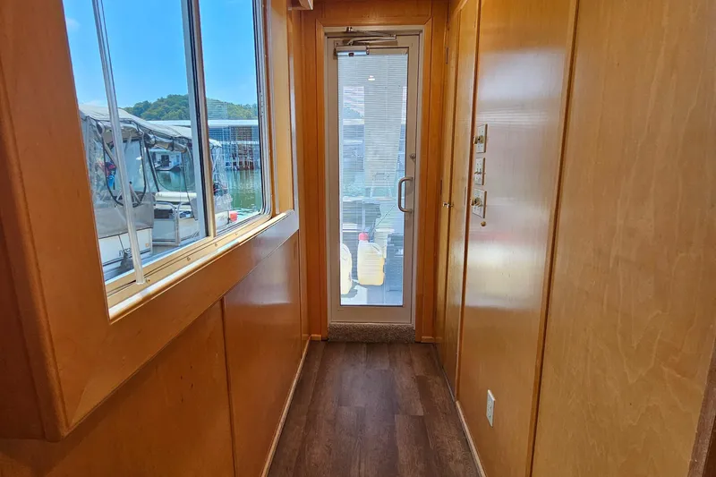 Slide: The Image of Narrow hallway in a 2001 Fantasy 18x80 houseboat with wooden walls and glass door. - 42