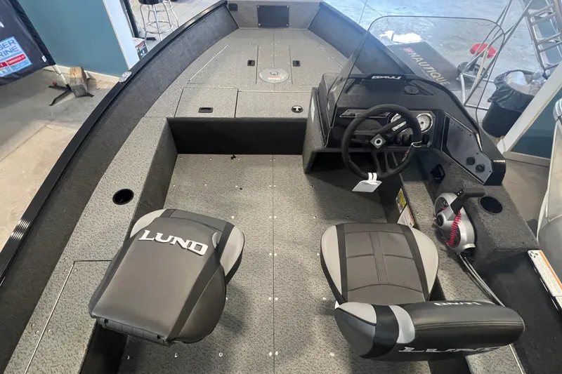 Slide: The Image of 2025 Lund 1650 Angler SS boat interior with steering console and seating. - 5