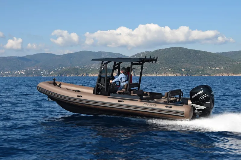 The Image of 2025 Brig Navigator 26 boat cruising on open water with scenic mountain backdrop. - 0
