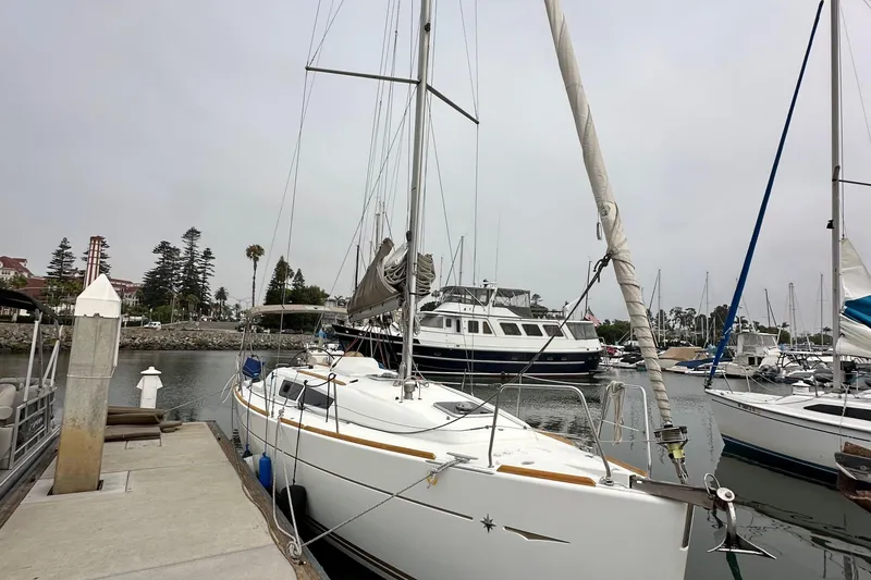 Slide: The Image of 2011 Jeanneau Sun Odyssey 33i sailboat docked in a marina, surrounded by other boats. - 15