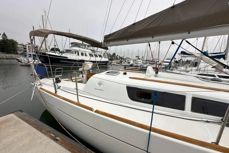 Slide: The Image of 2011 Jeanneau Sun Odyssey 33i sailboat docked in a marina, surrounded by other boats. - 19
