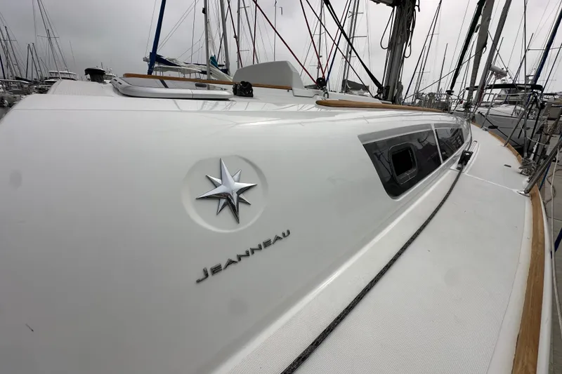 Slide: The Image of 2011 Jeanneau Sun Odyssey 33i sailboat docked, showcasing sleek design and branding. - 21