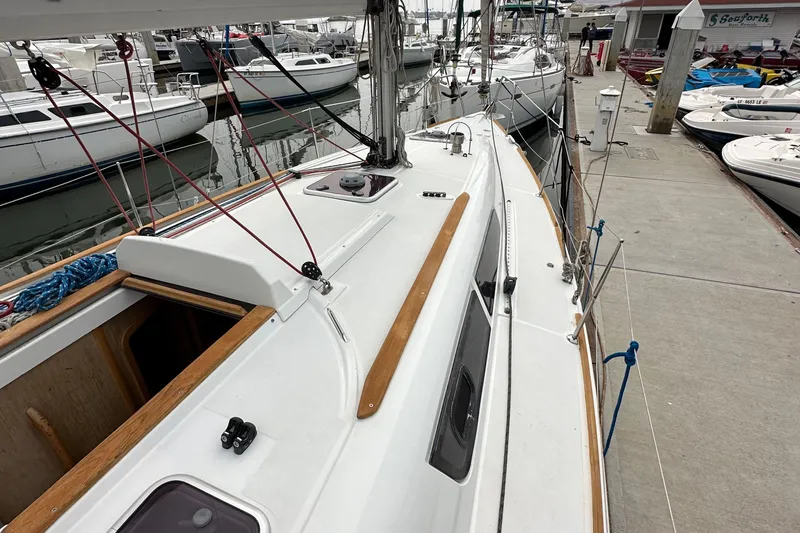 Slide: The Image of 2011 Jeanneau Sun Odyssey 33i sailboat docked at marina, showcasing deck and rigging. - 22