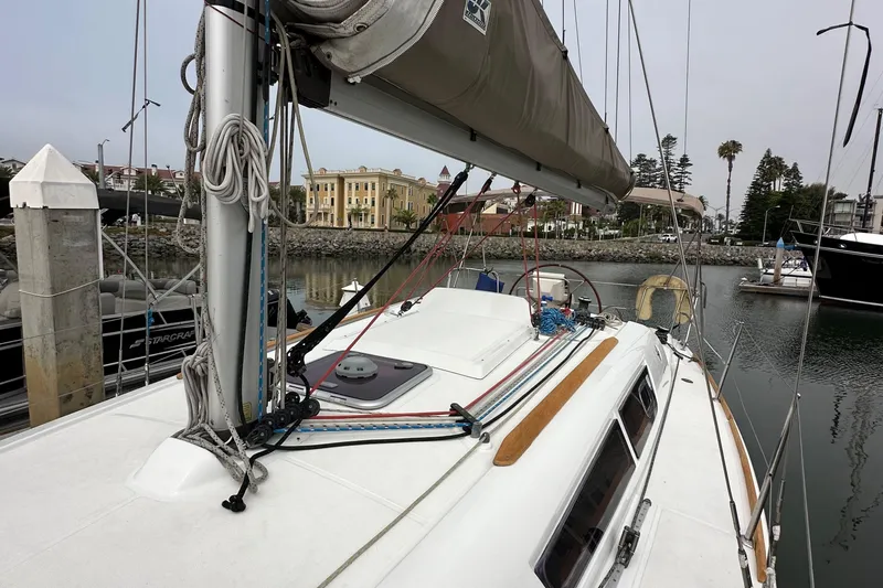 Slide: The Image of 2011 Jeanneau Sun Odyssey 33i sailboat docked in a marina, showcasing deck and rigging. - 29