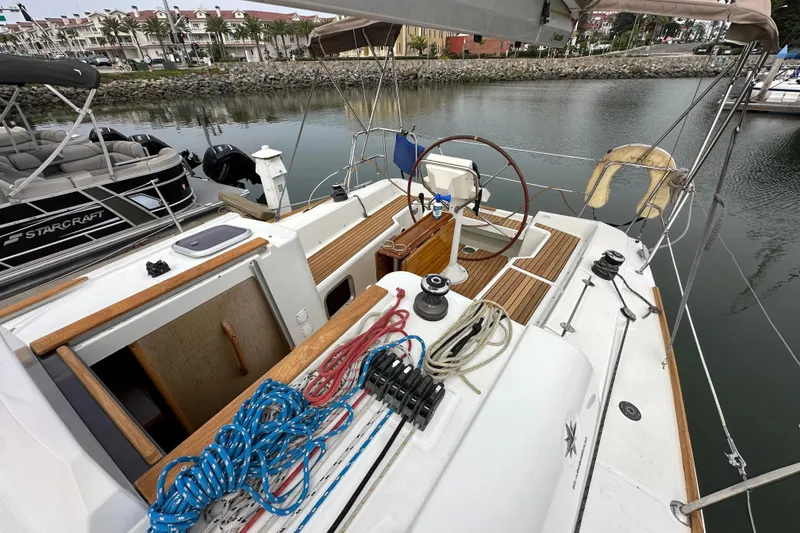 Slide: The Image of 2011 Jeanneau Sun Odyssey 33i sailboat cockpit with ropes and steering wheel, docked in marina. - 30