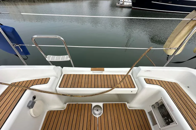 Slide: The Image of Cockpit of 2011 Jeanneau Sun Odyssey 33i sailboat with teak flooring and water view. - 33