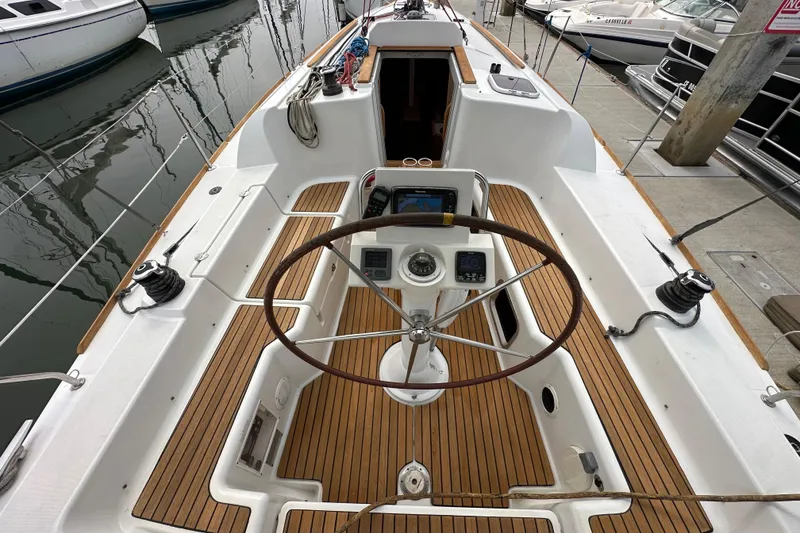 Slide: The Image of Cockpit of 2011 Jeanneau Sun Odyssey 33i sailboat with wooden deck and steering wheel. - 35
