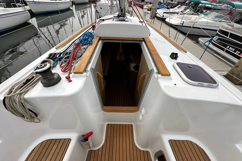 Slide: The Image of 2011 Jeanneau Sun Odyssey 33i sailboat cockpit with open cabin entrance, docked at marina. - 38