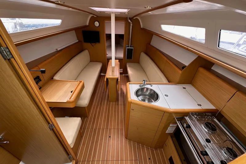 Slide: The Image of Interior of 2011 Jeanneau Sun Odyssey 33i sailboat with wood finish and compact kitchen. - 40