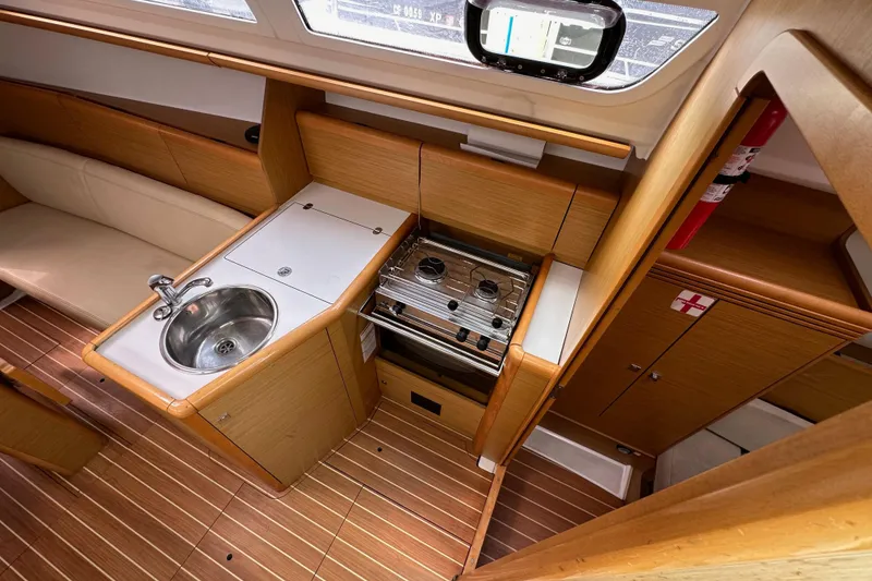 Slide: The Image of Interior of 2011 Jeanneau Sun Odyssey 33i yacht, featuring compact kitchen with sink and stove. - 41