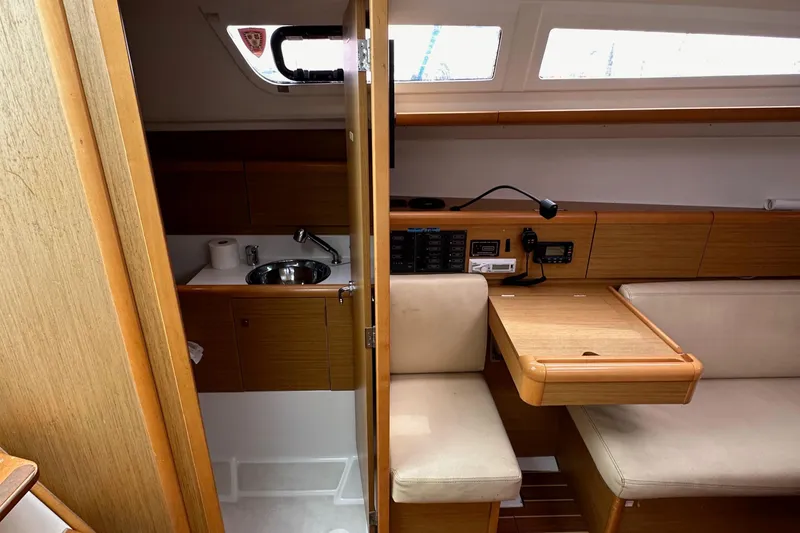 Slide: The Image of Interior of 2011 Jeanneau Sun Odyssey 33i yacht, featuring a compact galley and seating area. - 45