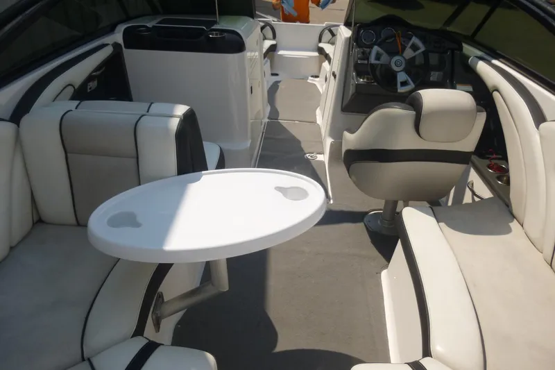 Slide: The Image of Interior of 2014 Yamaha Boats 240, featuring seating and steering area with a small table. - 14