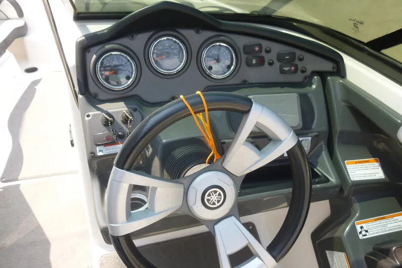 Slide: The Image of 2014 Yamaha Boats 240 dashboard with steering wheel and gauges. - 15