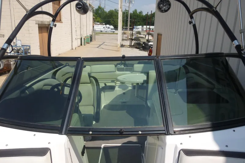 Slide: The Image of 2014 Yamaha Boats 240 with sleek windshield and spacious interior, parked outdoors. - 18