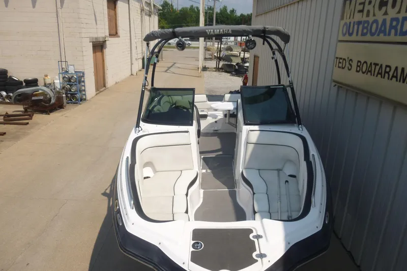 Slide: The Image of 2014 Yamaha Boats 240, white interior, parked at a marina. - 3