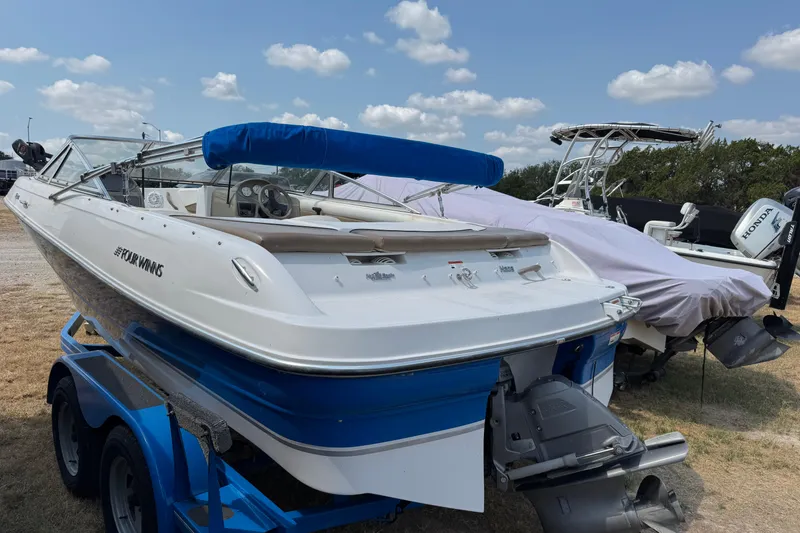 Slide: The Image of 2008 Four Winns H203 boat on trailer, blue and white design, parked outdoors. - 2