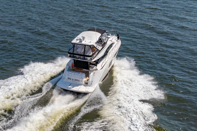 Slide: The Image of 2017 Sea Ray Fly 510 yacht cruising on open water, creating a wake. - 12
