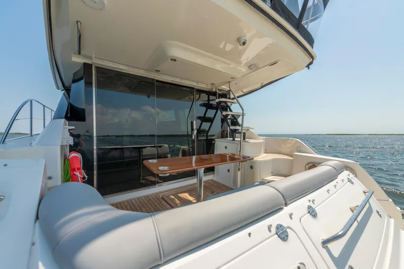Slide: The Image of 2017 Sea Ray Fly 510 yacht deck with seating and ocean view. - 15